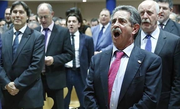 El presidente de Cantabria cantando el himno durante un acto.