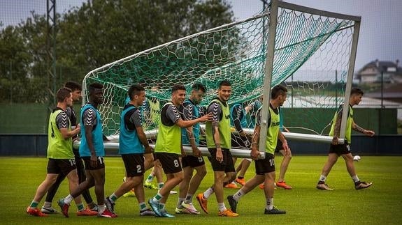 Los futbolistas del Racing acarrean una portería en los entrenamientos en La Albericia