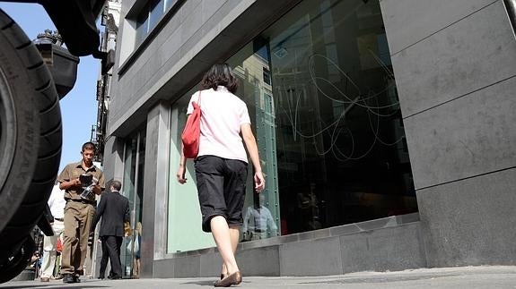 Varias personas pasan por delante de la sede de Liberbank en Madrid.