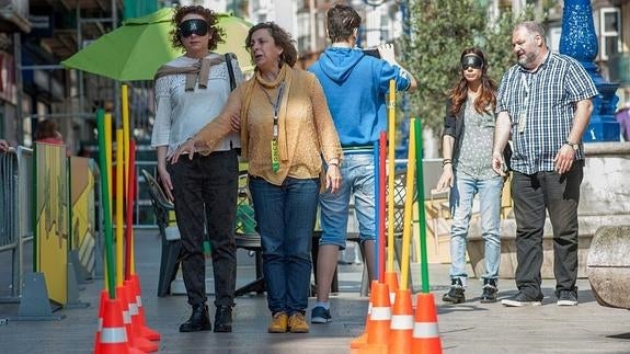 El paso por una zona de obras estrecha obliga a colocarse detrás del guía sujetando su brazo.