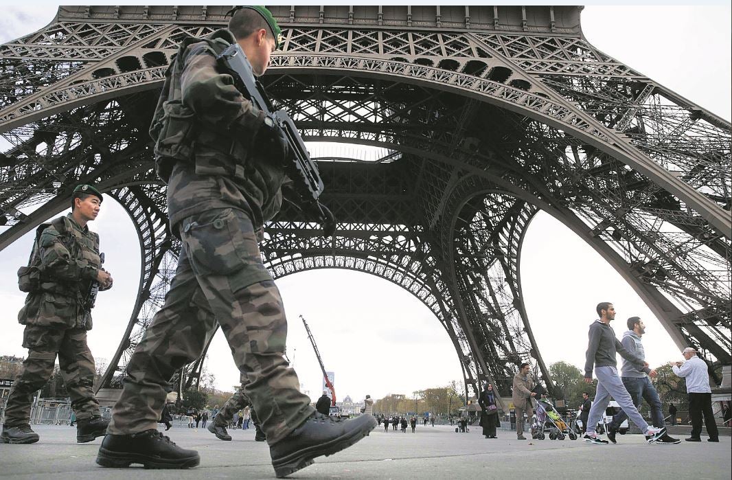 Soldados franceses patrullan en las inmediaciones de la Torre Eiffel, en París. :: 