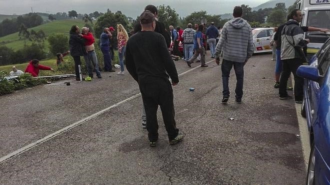 A la derecha, el coche accidentado, delante de algunos de los heridos tendidos sobre el asfalto. A la izquierda, otros espectadores suben desde la cuneta a la que se vieron desplazados. ::