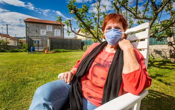 Marisa Toca Gutiérrez, enferma de Sensibilidad Química Múltiple, con su mascarilla de carbón activo, en su jardín en San Román. 