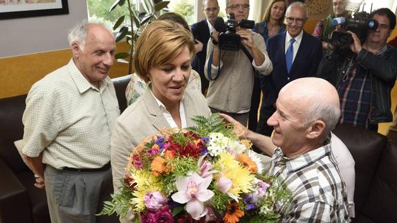 María Dolores de Cospedal recibe un ramo durante su visita a la Obra San Martín.