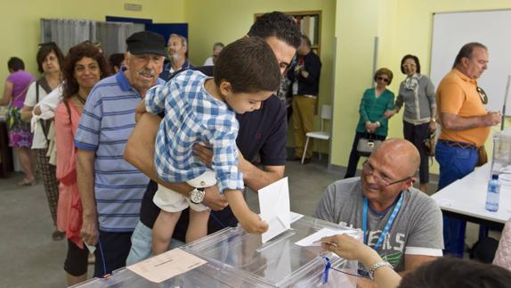 Un niño introduce el voto en el colegio electoral del Barrio Pesquero, en Santander