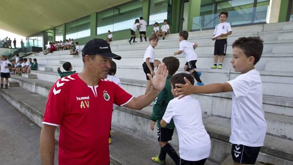 Angel Viadero, entrenador del Racing, saluda a los niños del campus de verano del club.