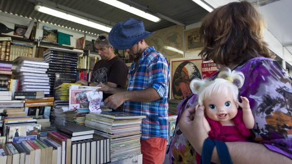 Clientes en busca de libros en un estand de la Feria