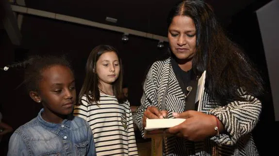 La escritora Asha Miró firma un libro a petición de dos niños que asistieron al encuentro con familias adoptivas 