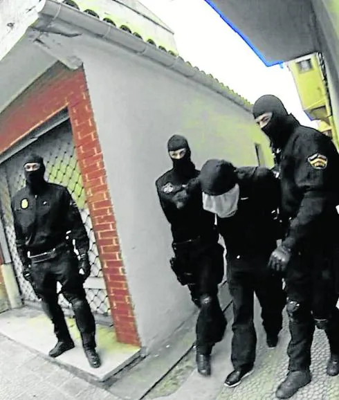 Agentes de asalto se llevan a Antonio Ortiz por el callejón de la Bajada de San Juan. 