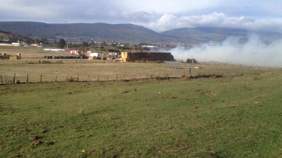 Los bomberos intentan extinguir el incendio y salvar las pacas que quedan.