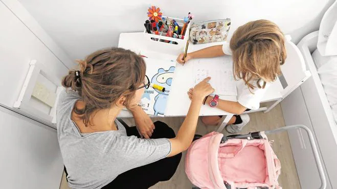 Una madre ayuda a su hija a realizar los deberes