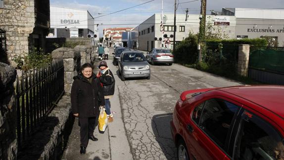 Dos mujeres caminan por el Paseo del Niño, a la altura del paso a nivel de las vías del tren.