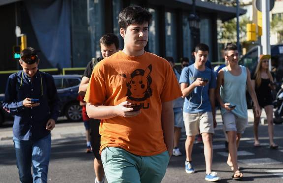 Adolescentes con sus correspondientes móviles, en este caso a la caza de Pokémons 