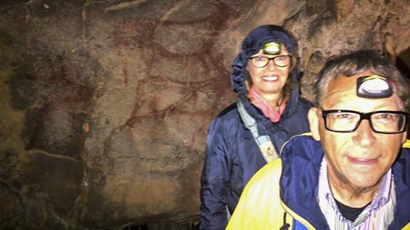 Stuart Weitzman, con su asistente personal, Barbara Kreger, posan en la cueva delante de unas pinturas.