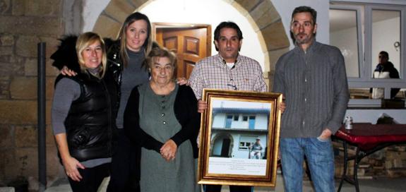 Aurora Castillo junto a sus hijos Juan Ignacio, Luis Alberto y Mar, y su nieta Diana, con una foto del padre de familia, Casto, frente a la nueva casa.