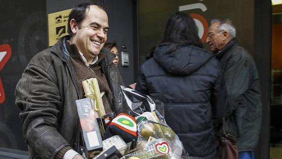 Un hombre camina por la calle con una cesta de Navidad.