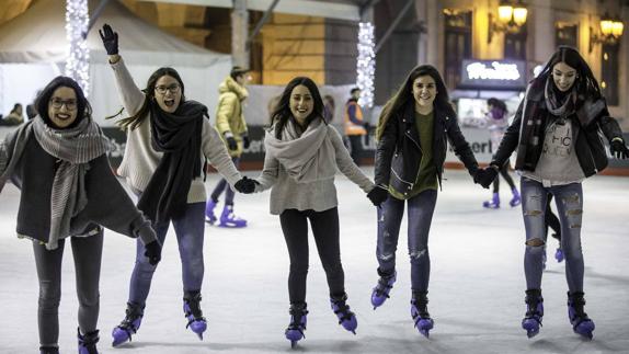 Un grupo de amigas disfruta de la pista de patinaje sobre hielo, en la plaza Porticada.