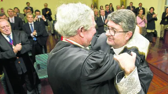 Andrés de Diego, nuevo decano, recibe el abrazo su antecesor en el cargo, Jesús Pellón.