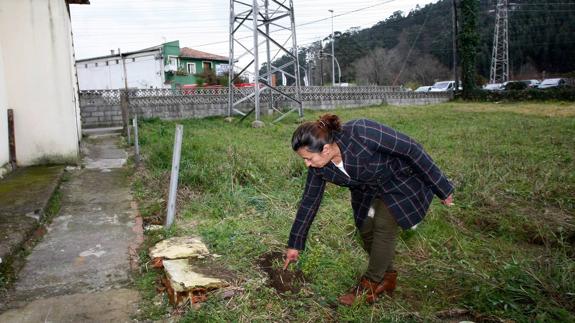 Daisy Loayza, una de las vecinas afectadas, señala uno de los socavones. 