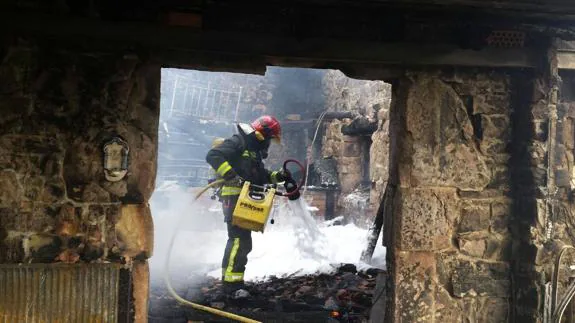 Un bombero echa espuma en el incendio de Selaya.