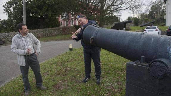 Dos miembros de la Asociación de Amigos del Museo explican cómo se carga. Al fondo, la vivienda del párroco.