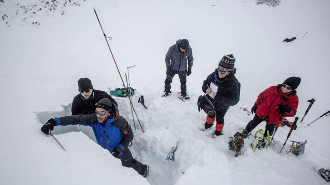 Aniceto Valle corta un bloque de nieve mientras Odón Hernández, Mara García y Pilar Sanz se prepara para hacer las mediciones.