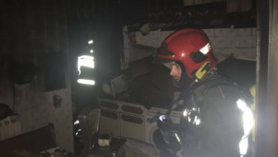 Los bomberos del 112, trabajando en la cocina incendiada.