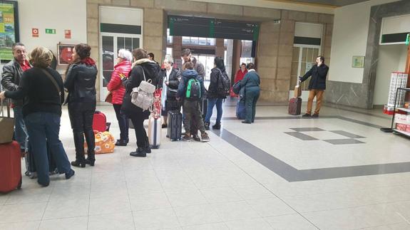 Cola de pasajeros en la estación de tren de Santander, a las 13.45 horas, esperando la llegada de los autobuses que los llevarán a Palencia.