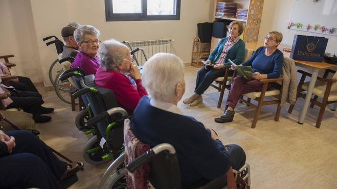 Dos de las voluntarias, durante una sesión de lectura a los mayores del municipio.