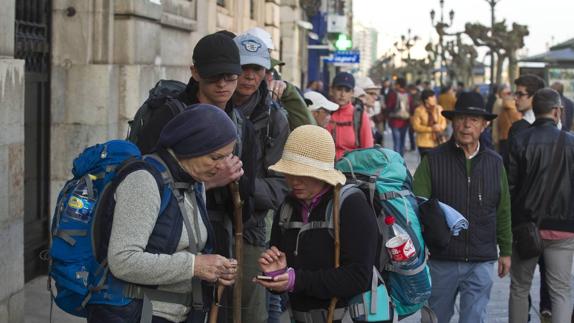 Un grupo de turistas se detiene en pleno Paseo de Pereda a consultar su destino en un teléfono móvil. 