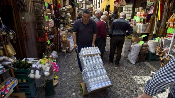 En Potes los establecimientos se abastecen para dar servicio al aluvión de visitantes que se esperan este fin de semana. En la imagen, un operario carga botellas de agua, ayer, en la capital de Liébana.