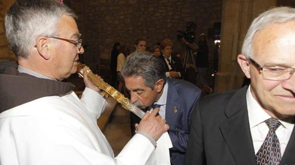 El presidente de Cantabria, Miguel Ángel Revilla, besando el Lignum Crucis este domingo.