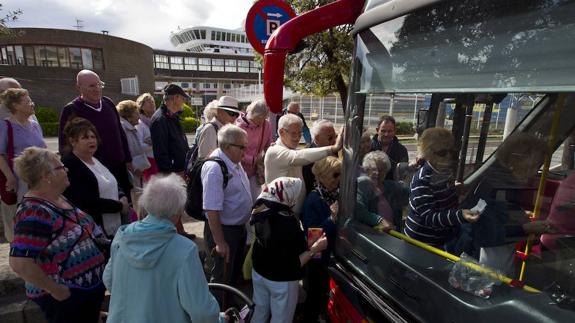 Varios turistas británicos se suben a un autobús después de abandonar el barco