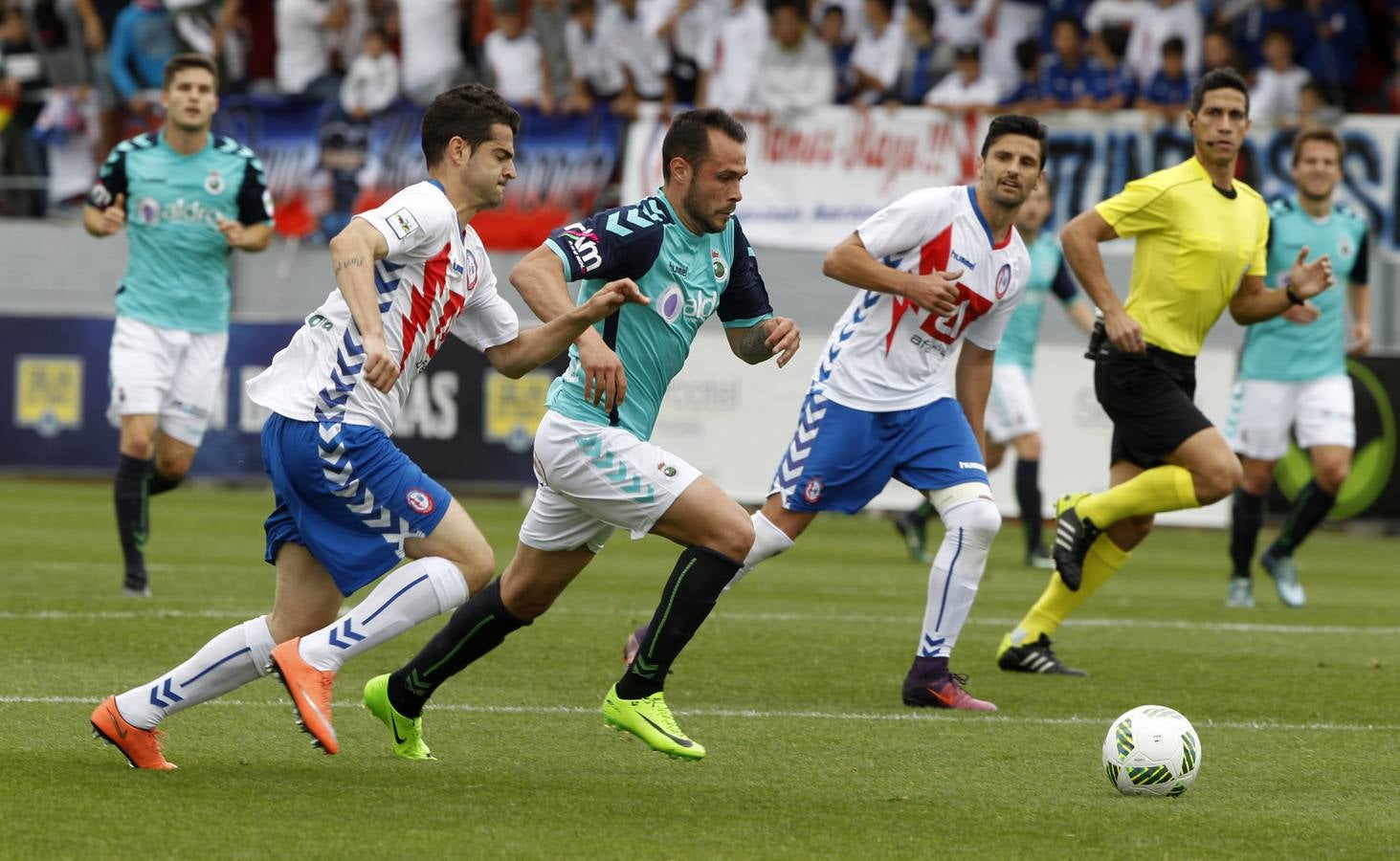 Santi Jara conduce el balón ante el acoso de dos jugadores del Rayo Majadahonda.