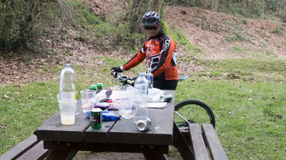 Un ciclista contempla los restos del botellón en un área de ocio del parque de La Viesca.