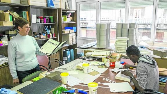 Sor Evelia, superiora de las monjas de la Cocina Económica, en el taller de manualidades de cartón y papel. Sostiene una carpeta para partituras hecha de encargo