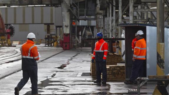 Estibadores portuarios realizan labores de carga en el puerto de Santander.