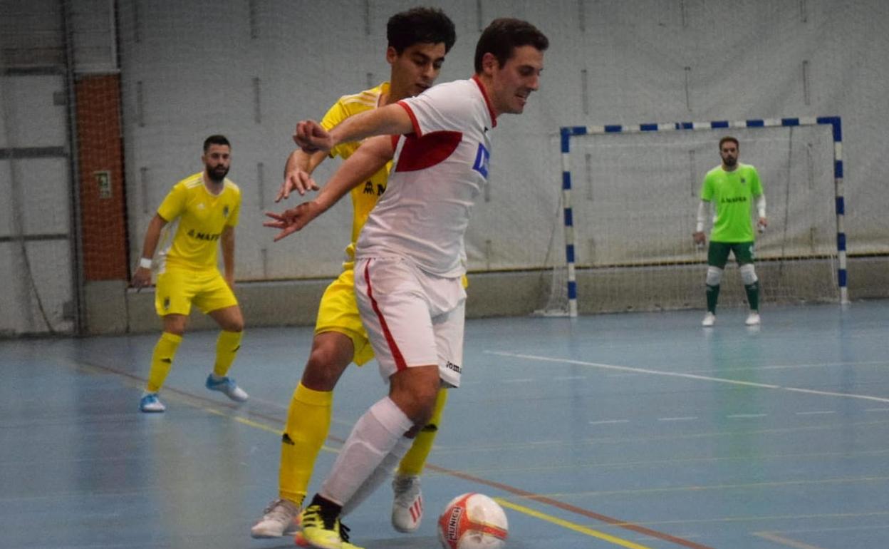 Un jugador del Unión Arroyo protege el balón ante la presión de un rival. 