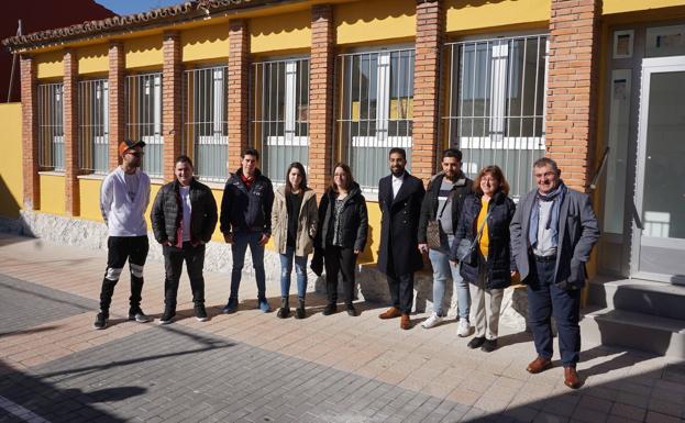 Grupo de alumnos y profesores que han recuperado las antiguas escuelas de La Flecha posando ante su entrada. 