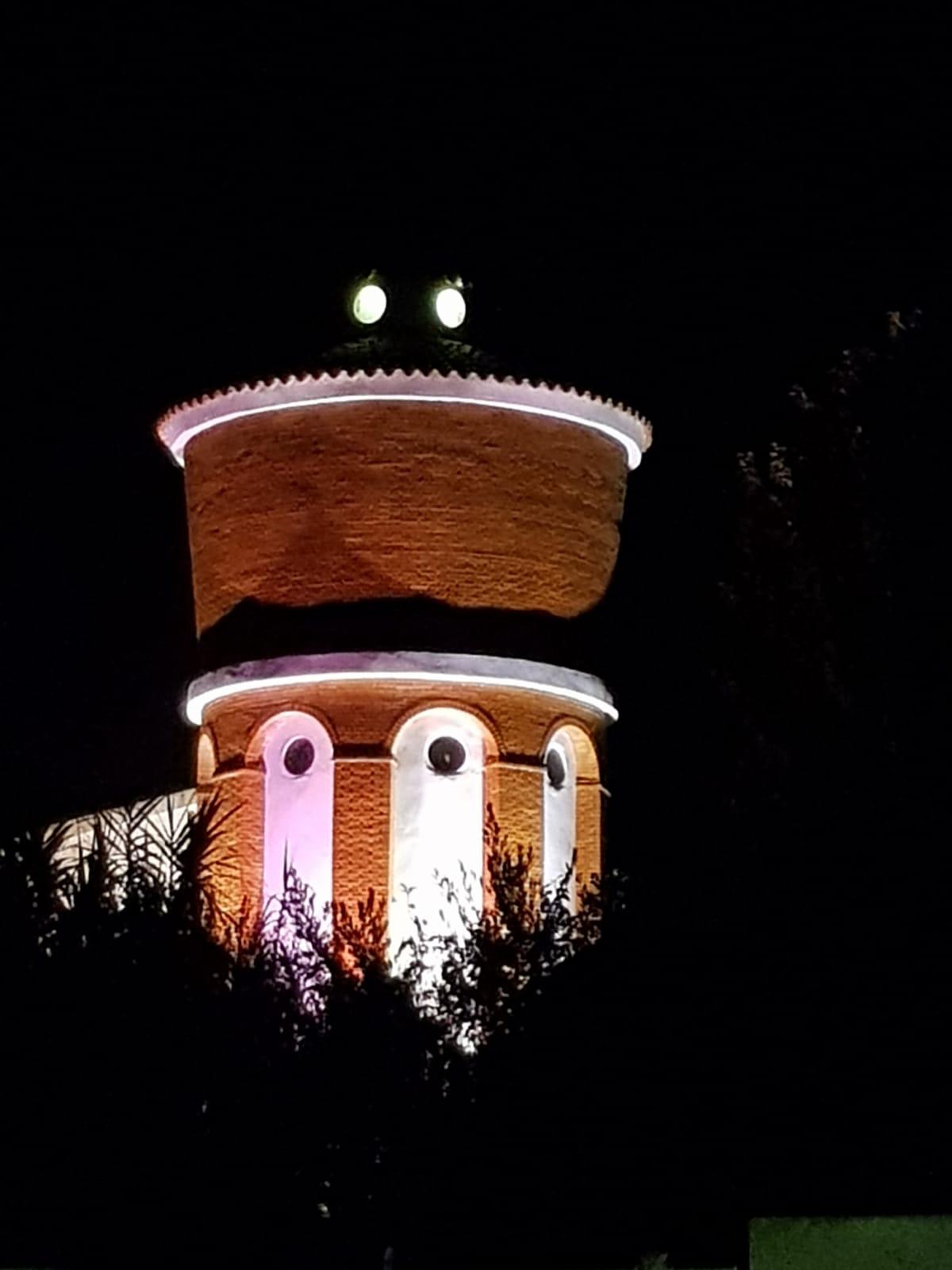 Pórtico de entrada a la iglesia de Arroyo iluminada en rosa. 