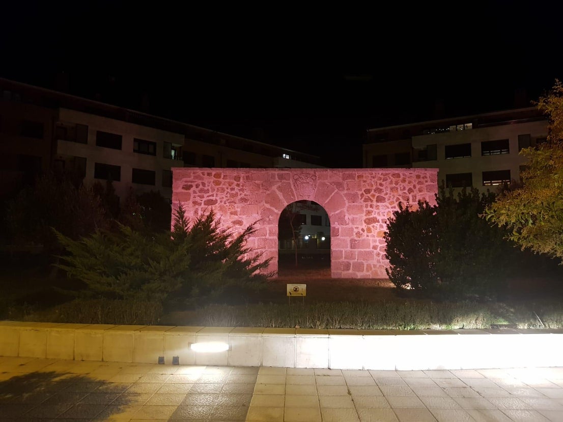 Pórtico de entrada a la iglesia de Arroyo iluminada en rosa. 
