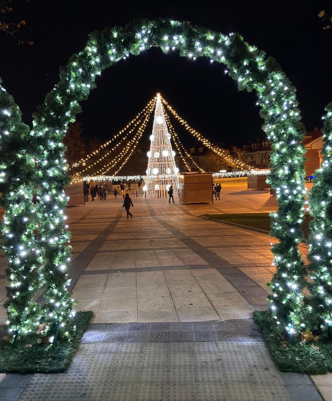 Arcos iluminados de acceso a la Plaza España de La Flecha con el árbol de Navidad al fondo. 