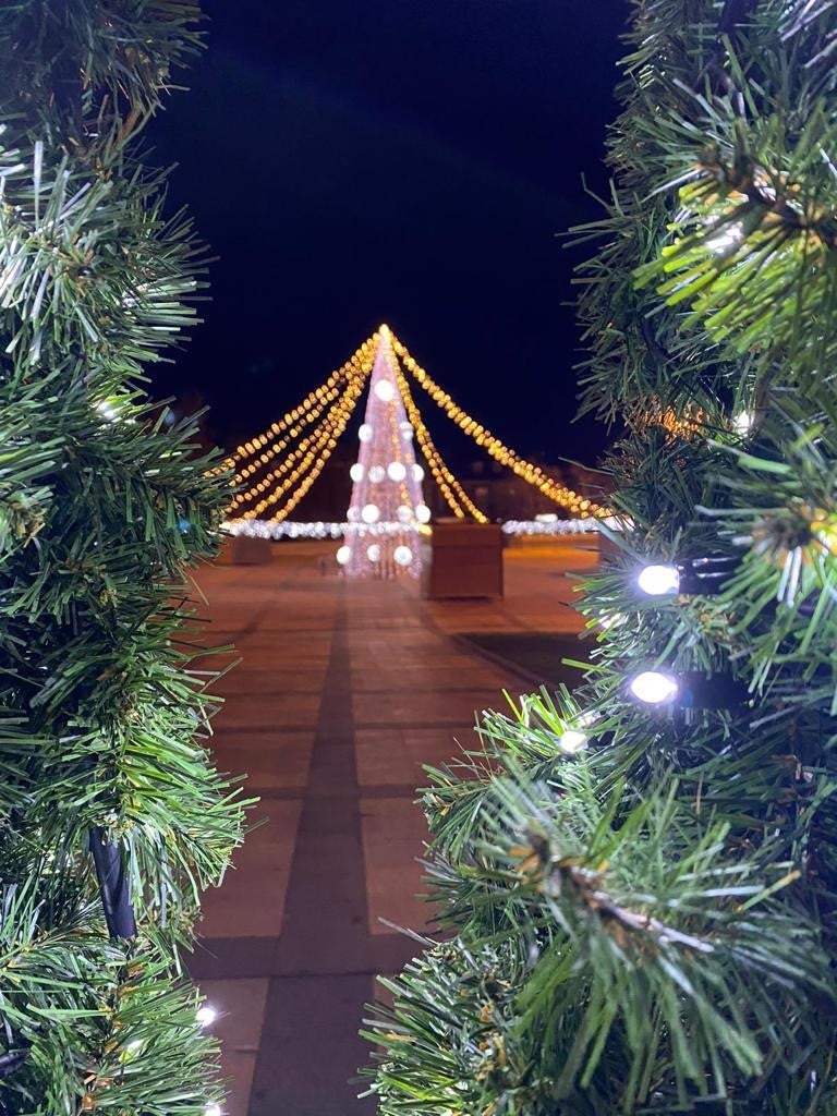 Arcos iluminados de acceso a la Plaza España de La Flecha con el árbol de Navidad al fondo. 