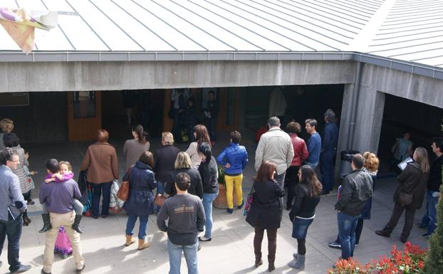 Padres esperando la salida del Margarita Salas de La Vega de sus hijos un mediodía. 