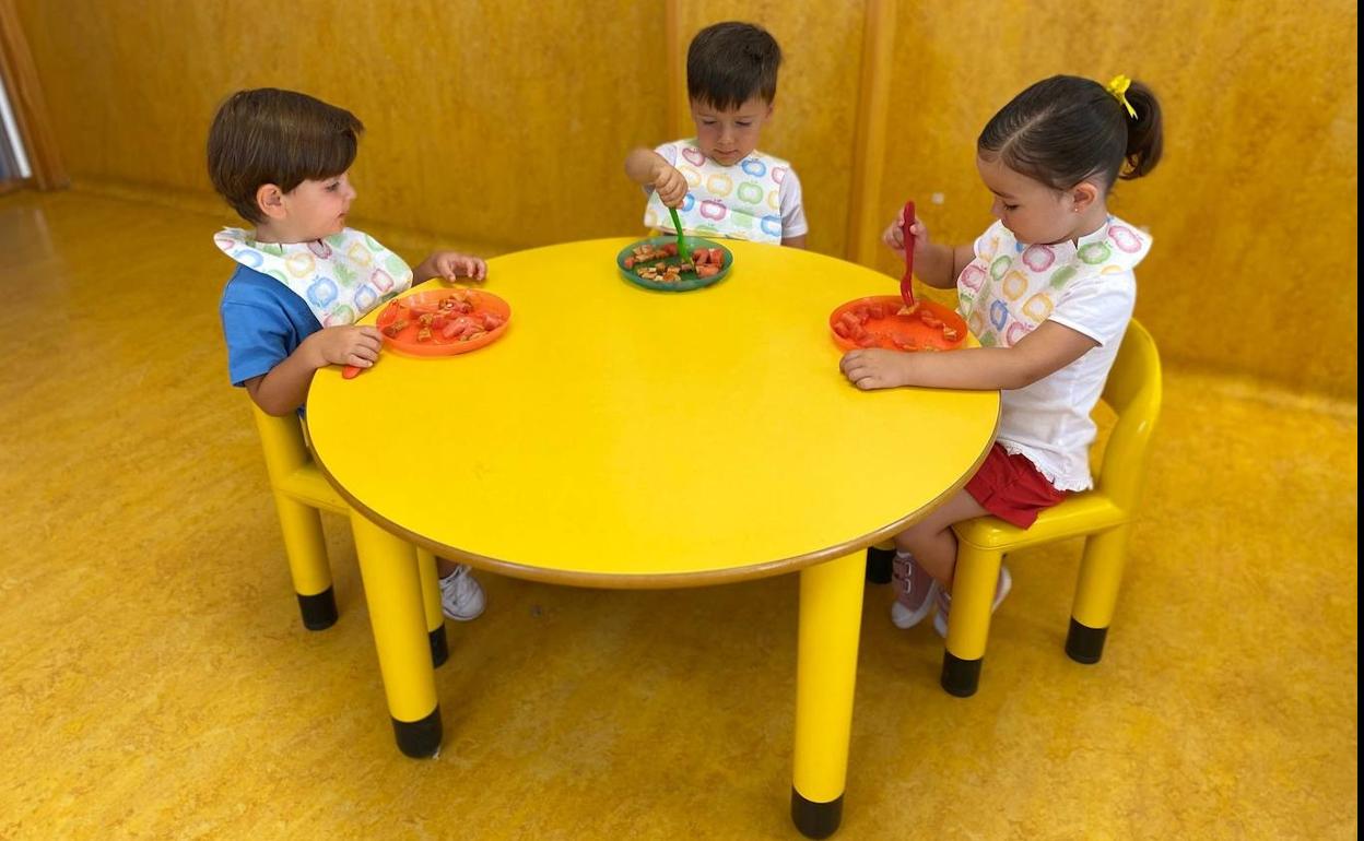 Tres niños comiendo en una de las escuelas 