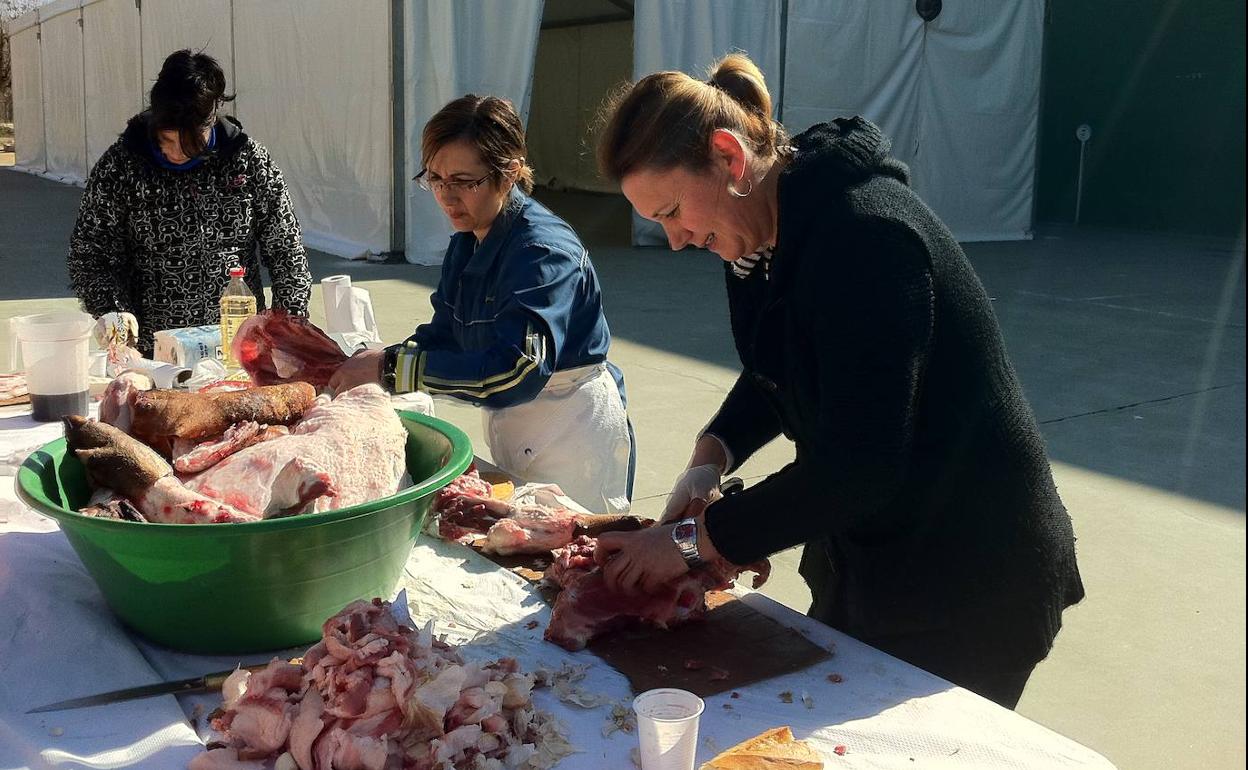 Varias mujeres despiezan el cerdo en Arroyo en una edición anterior de la fiesta. 