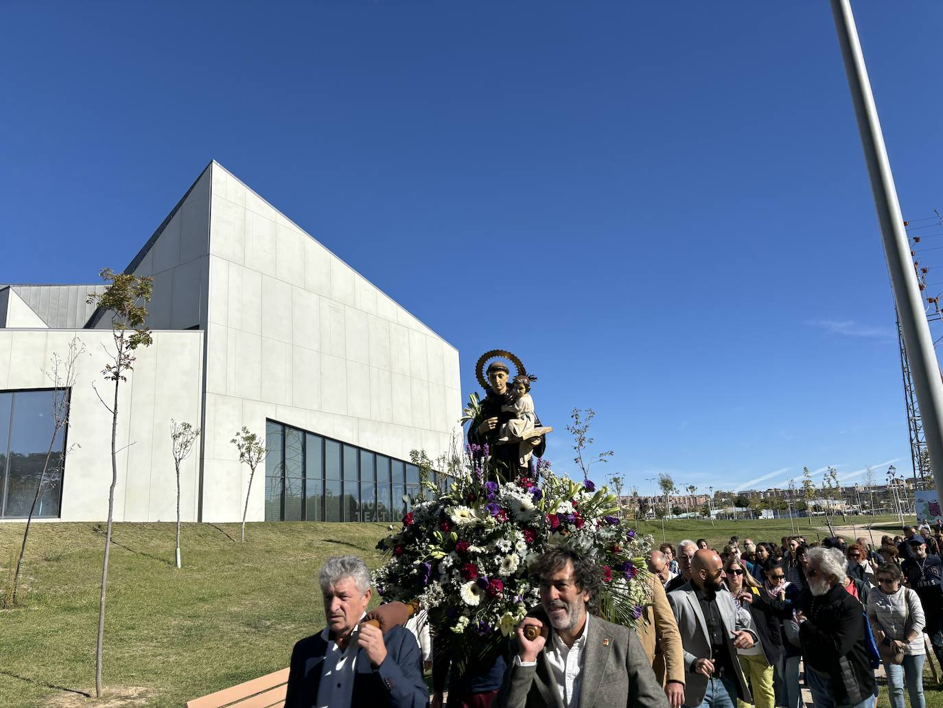 El alcalde Sarbelio Fernández y el concejal Juan Manuel Sánchez portando la imagen de San Antonio de Padua frente a la Casa de la Música y el Teatro de Arroyo