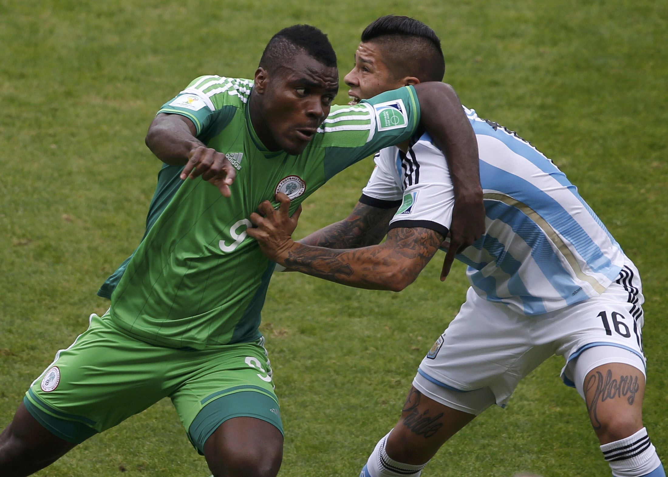 Rojo (d) intenta detener a Emenike durante un momento del partido.