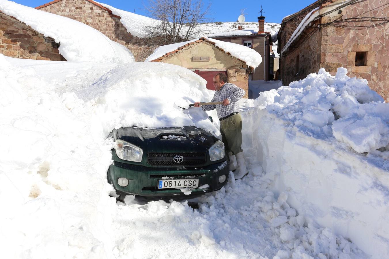 Elías vecino de Brañosera quita la nieve de su vehículo.