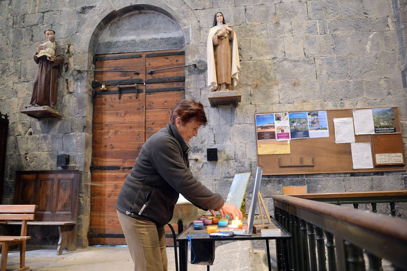 La capilla, preparada para recibir a las familias. SEYNE LES ALPES (FRANCIA). Una mujer enciende una vela en la capilla de la localidad de Seyne les Alps, que ha sido habilitada por si alguno de los familiares necesitara utilizarla.